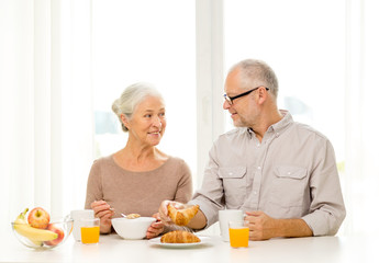 Fototapeta na wymiar happy senior couple having breakfast at home