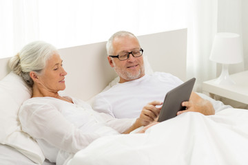 Fototapeta premium happy senior couple with tablet pc at home