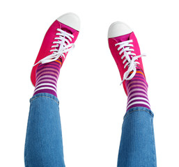 Female legs in colorful socks and sneakers isolated on white