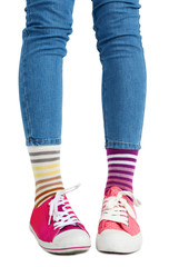 Female legs in colorful socks and sneakers isolated on white