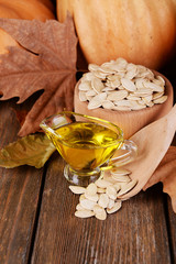 Pumpkin seed oil in glass sauce-boat and fresh pumpkin