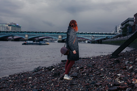 Young woman standing on river bank in city