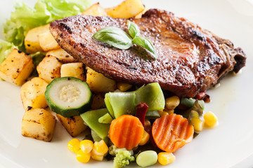 Fried pork with potatoes and vegetables salad