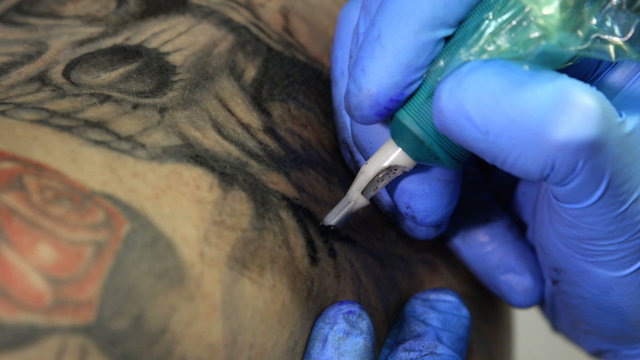 Tattoo artist tattooing a skull
