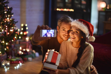 Handsome couple in their living room at  christmas eve, the youn