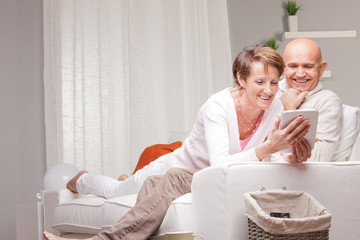 mature couple watching funny things on a tablet