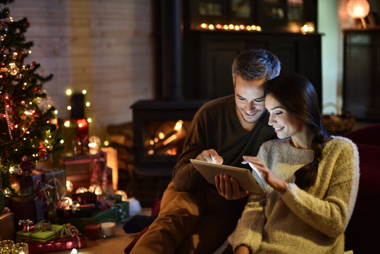 Handsome Couple In Their Decorated Living Room At  Christmas Eve