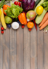 Fototapeta na wymiar Fresh organic fruits and vegetables on wooden background