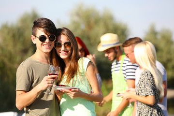 Young couple with friends on rest, outdoors