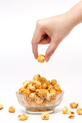 Hand picking caramel popcorn filled in crystal clear bow - 72702178