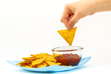 Dipping tortilla chips with salsa sauce in dish on white backgro