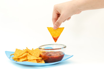 Dipping tortilla chips with salsa sauce in dish on white backgro - 72702578