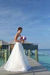 Fototapeta na wymiar Asian bride in seaside wedding pose