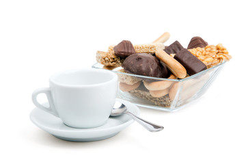 white cup of tea and a selection of sweets on a white background