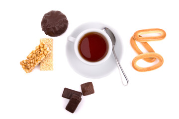 white cup of tea and a selection of sweets on a white background