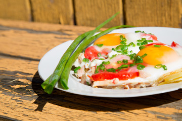 eggs, green onions and tomatoes on an old wooden table