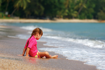Small girl sitting on sand