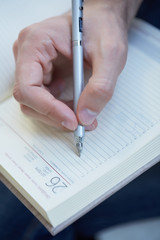 man writes in datebook