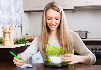 Happy woman weighing cottage cheese