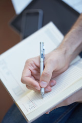 man writes in datebook