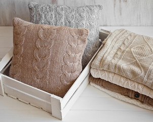 Cozy wool winter accessory. Warm sweaters and pillow