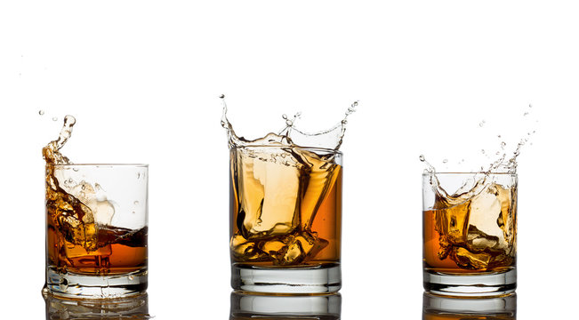 Whiskey splash in a glass, isolated, white