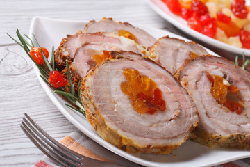 pork roll with apricot and cherry closeup on a white plate