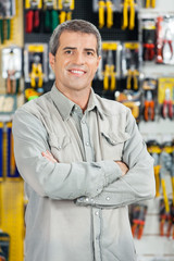 Fototapeta premium Happy Man Standing Arms Crossed In Hardware Store