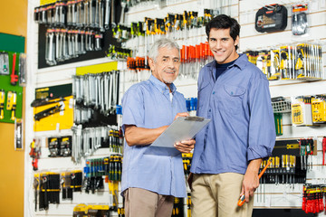 Father And Son With Clipboard In Hardware Store