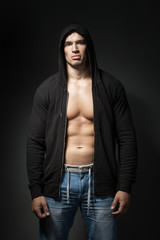 strong man wearing black hoodie isolated on dark background