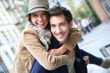 Man giving piggyback ride to girlfriend, having fun