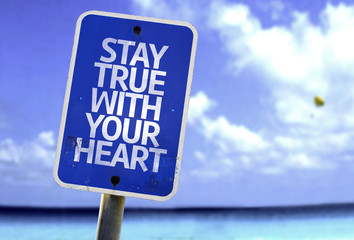 Stay True With Your Heart sign with a beach on background