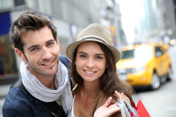Fototapeta na wymiar Portrait of cheerful couple doing shopping in Manhattan
