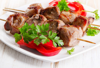 Pork kebabs served  on a white plate