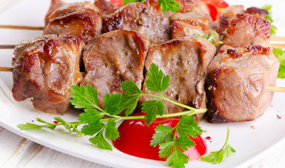 Pork kebabs served  on  white plate