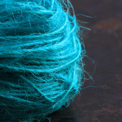 Close-up view of a roll of string on a brown rustic background
