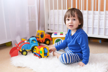 lovely 2 years boy plays cars at home