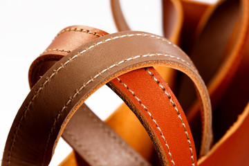 Close up of a brown leather belt isolated on white