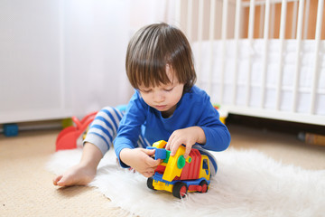 lovely little boy plays cars at home