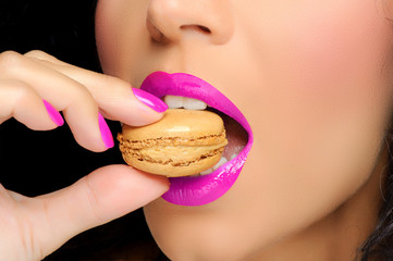 Close up to Macaroon on hand , beautiful caucasian woman eating