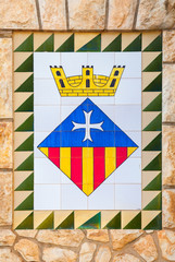 Calafell town Coat of arms on the old stone wall