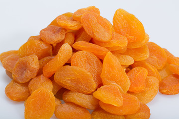 A heap of dried apricots on a white background