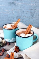 Cups of tasty hot cocoa on table, on light background