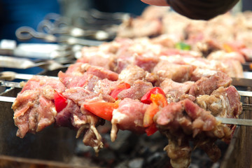 Marinated shashlik, meat grilling on metal skewer, close up