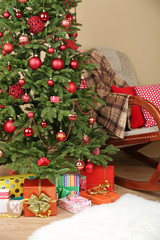 Decorated Christmas tree with gifts in room closeup
