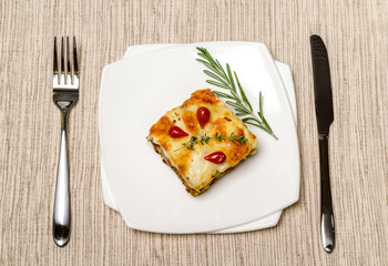 Portion of lasagna on the wooden table