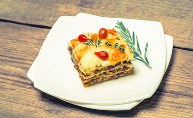 Portion of lasagna on the wooden table