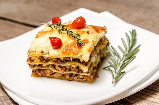 Portion of lasagna on the wooden table