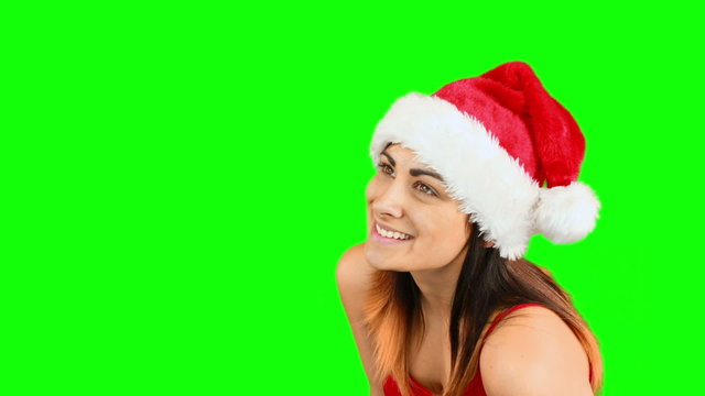 Pretty girl in santa hat blowing over hands