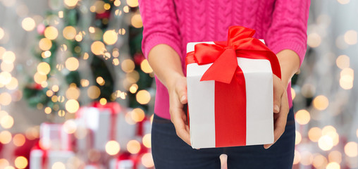 close up of woman in pink sweater holding gift box